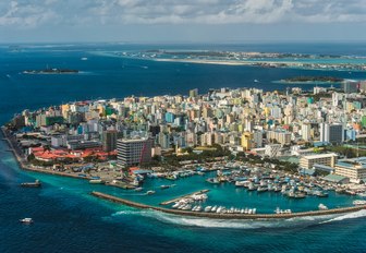 aerial shot of maldives island capital with skyscrapers and marina