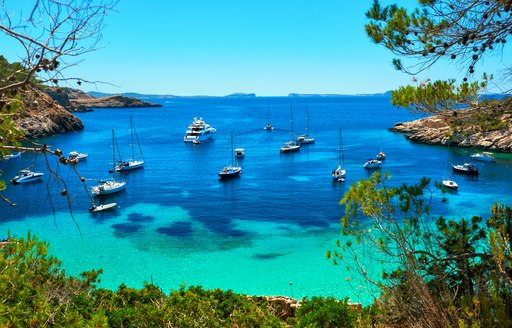 Yachts anchored in a sheltered cove in Ibiza
