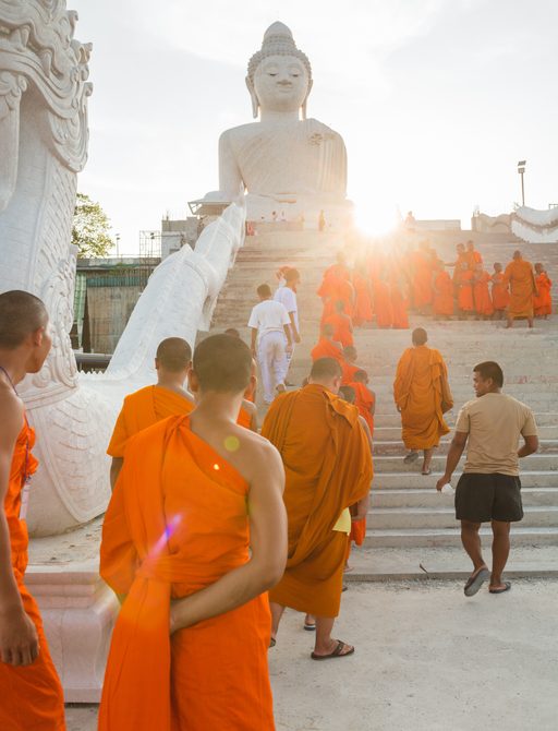 Young buddhists in orange clothes near the Big Buddha Temple in Phuket in Thailand