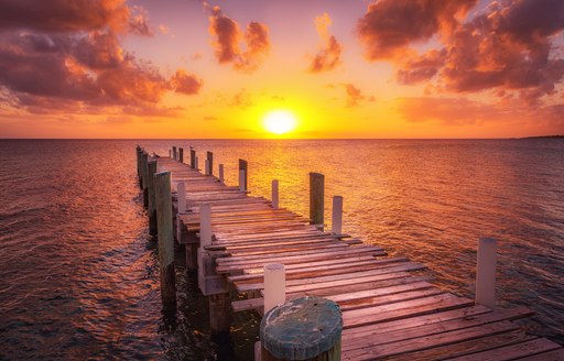 Dock during caribbean sunset, beautiful magenta colors and perspective of this boat dock and fishing dock in Eleuthera island