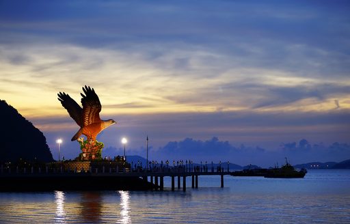 a large eagle statue looks out into the bay at kuah in langkawi malaysia