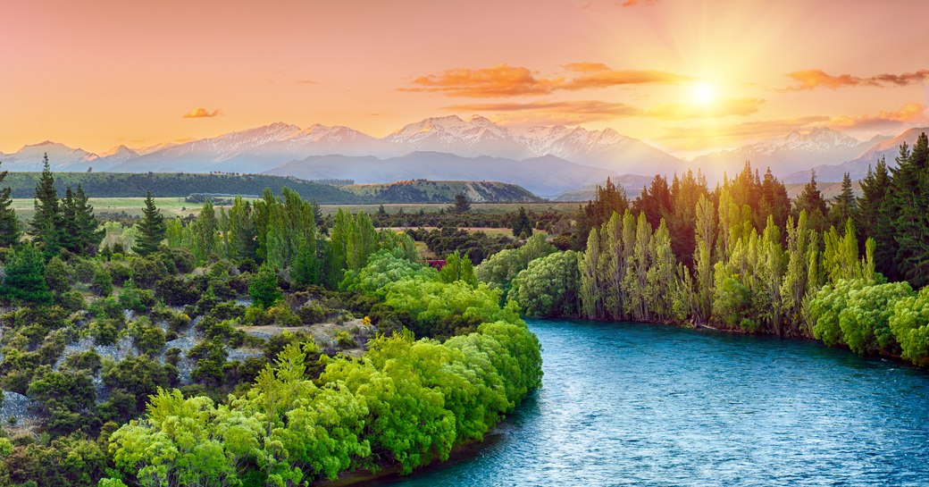 Beautiful sunset over the bend of the river Clutha with Southern Alps peaks on the horizon, New Zealand