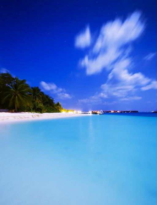 Blurred shot of a beautiful sand beach with turquoise waters and azure skies and clouds in the Maldives
